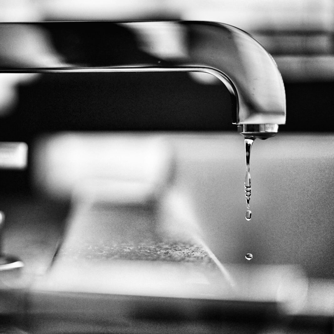 grayscale photography of faucet